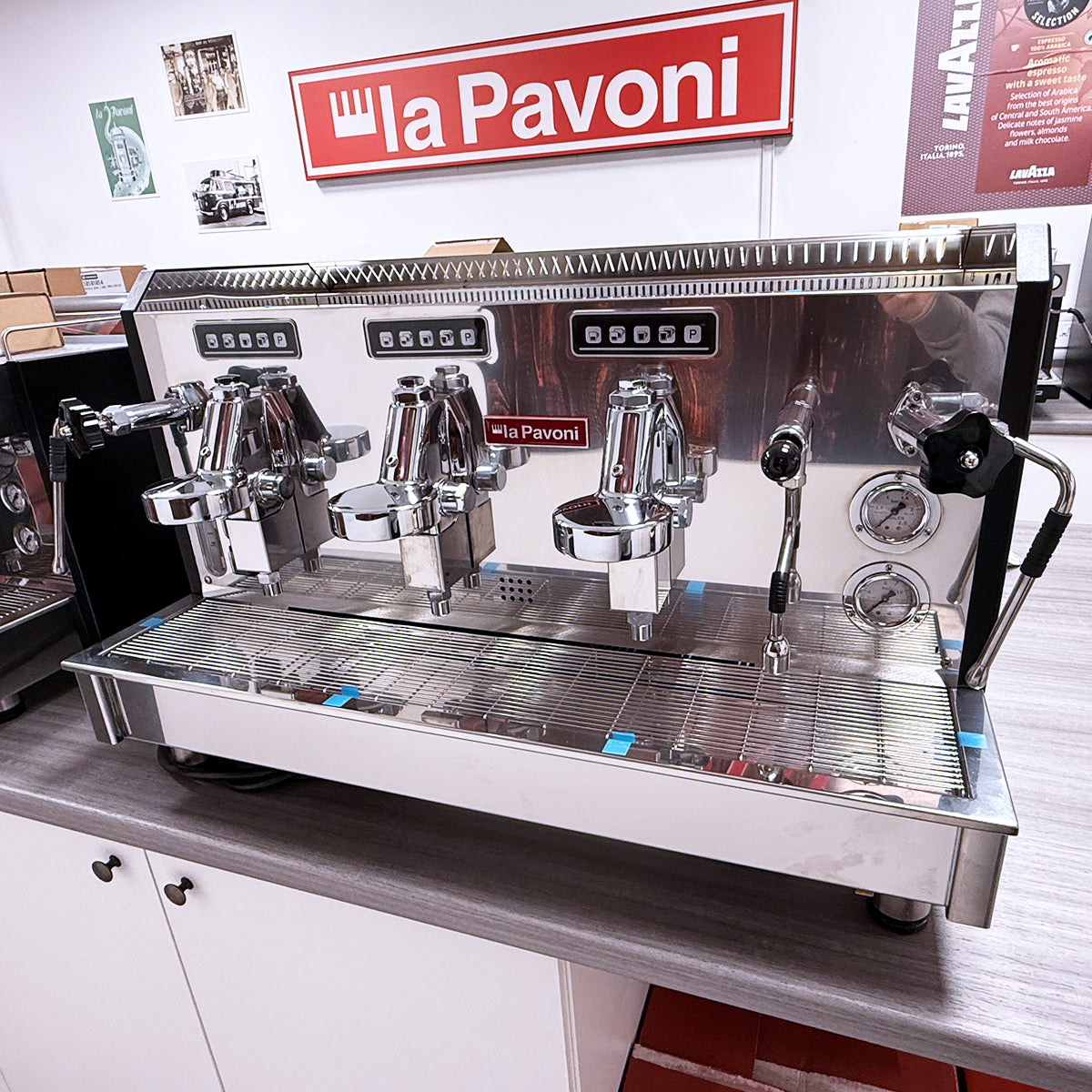 A professional La Pavoni commercial espresso machine with three groups, stainless steel finish, and drip tray.